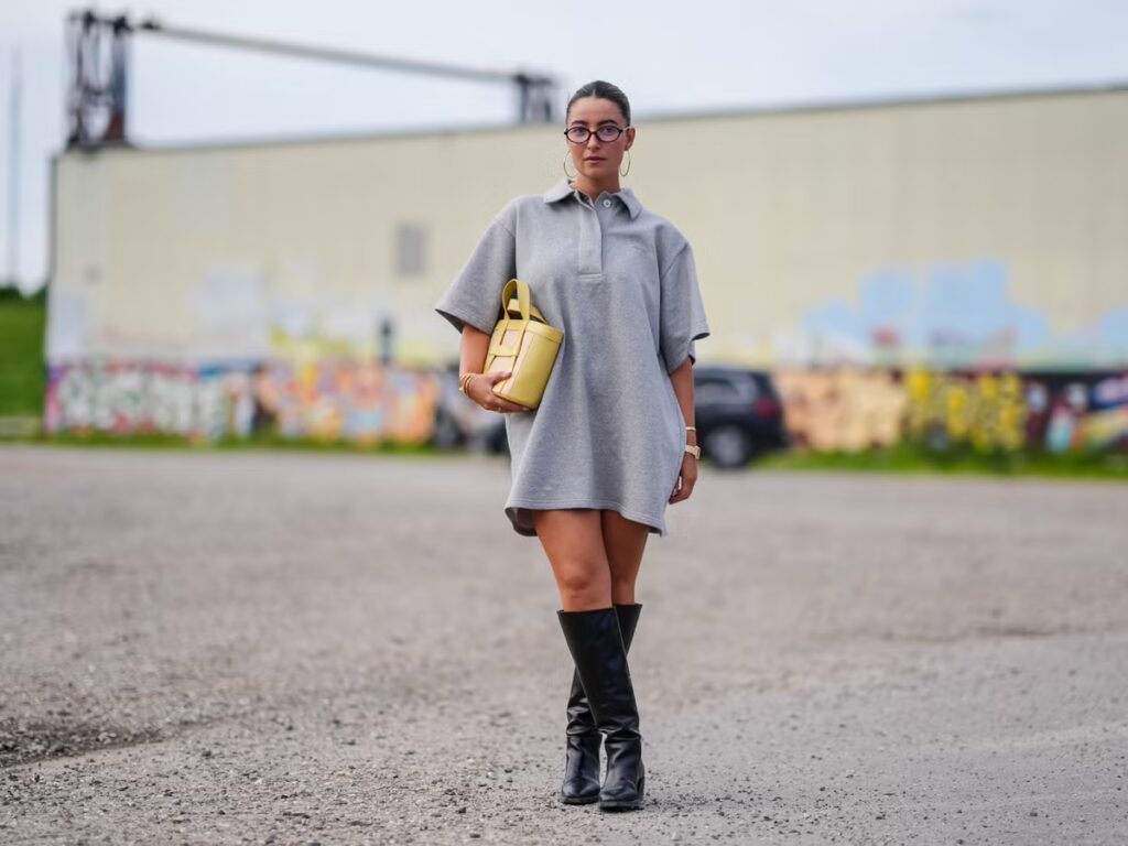 Show a model wearing knee-high suede slouchy boots with a flowy midi dress.